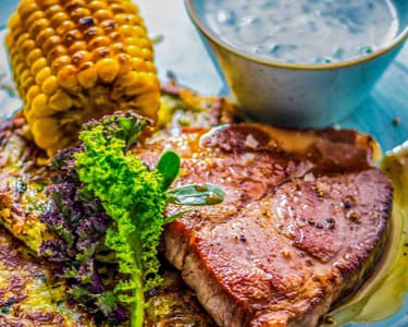 Sous vide Pork Neck Steak with Zucchini Fritters, Grilled Corn, and Dill Yogurt