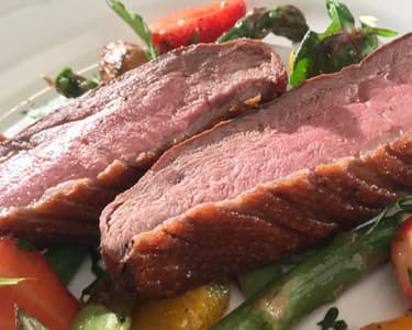 Pink duck breast with spring vegetables