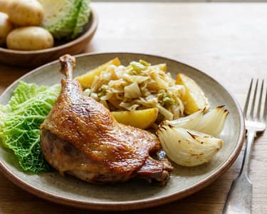 Duck leg with cabbage potatoes and roasted onions