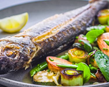 Egészben sült farkassügér, roppanós zöldségekkel, vajmártással