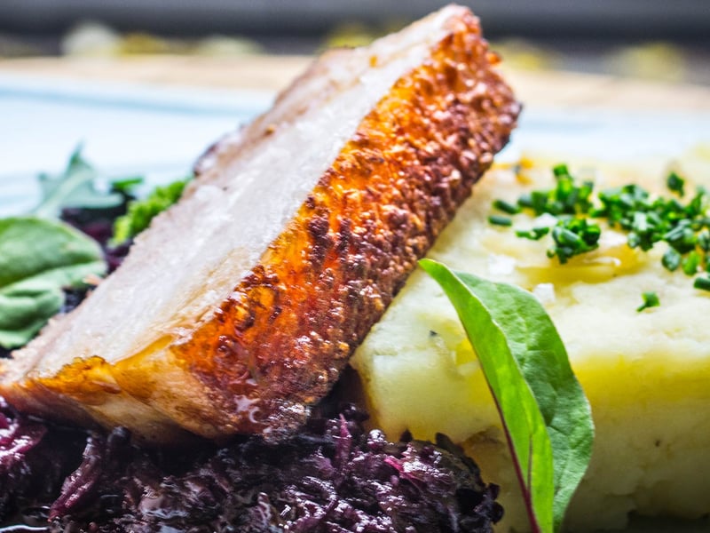 Sous vide pork belly with potato and cabbage, star anise red cabbage, and pan jus